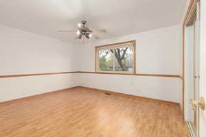 Empty room featuring baseboards, ceiling fan, and light wood finished floors