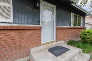 Property entrance featuring brick siding