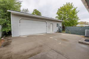 Detached garage featuring central air condition unit and fence