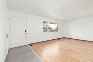 Interior space featuring baseboards, a textured ceiling, and visible vents