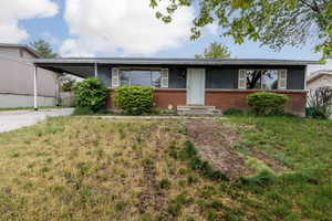 Ranch-style house with brick siding, driveway, and a carport