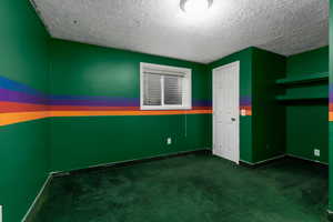 Unfurnished room with baseboards, carpet flooring, and a textured ceiling