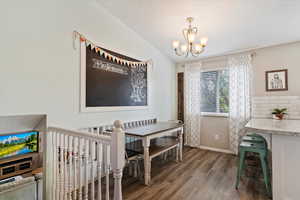 Dining area featuring wood finished floors, baseboards, and a notable chandelier