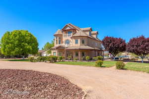 Victorian house with a tiled roof, a porch, and stone siding