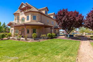 View of front of home featuring stone siding, a tile roof, and a front yard
