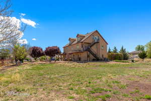 Back of house featuring fence and stairs