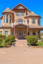 View of front facade with stone siding, a tile roof, and a balcony