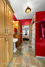 Ensuite bathroom featuring ceiling fan, visible vents, curtained shower, ensuite bathroom, and stone tile floors