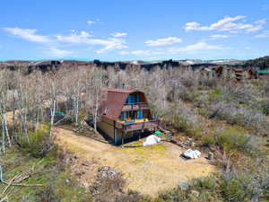 Rear view of house with a gambrel roof and a balcony
