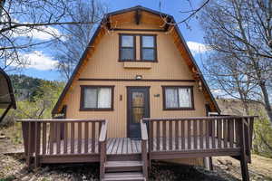 Rear view of cabin featuring a wooden deck