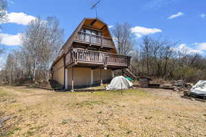 Rear view of cabin featuring a gambrel roof, and two decks