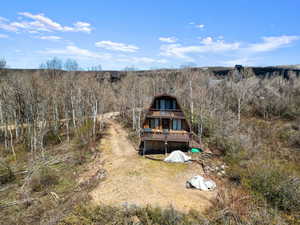 Rear view of house with a wooden deck and a balcony
