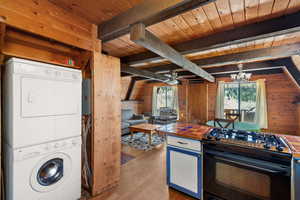 Kitchen, stacked washer and clothes dryer, and a wealth of natural light