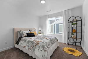 Bedroom with baseboards, visible vents, and carpet