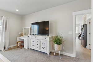 Bedroom featuring baseboards, freestanding refrigerator, visible vents, and multiple windows