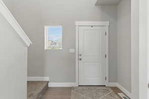 Entryway with visible vents, baseboards, and wood finished floors