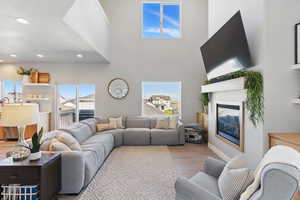 Living area featuring recessed lighting, a glass covered fireplace, and wood finished floors