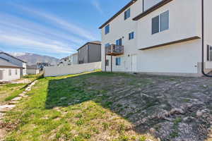 View of yard featuring a mountain view, a balcony, a residential view, and fence