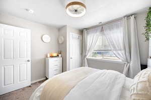 Bedroom with carpet floors, baseboards, a closet, and visible vents