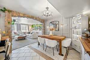 Dining room featuring an inviting chandelier, light tile patterned flooring, and visible vents