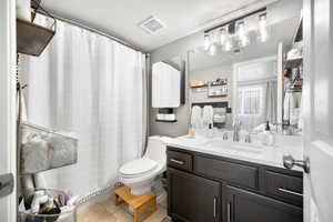 Bathroom with visible vents, vanity, toilet, a shower with shower curtain, and tile patterned floors