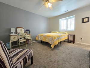 Bedroom with baseboards, carpet flooring, ceiling fan, and visible vents