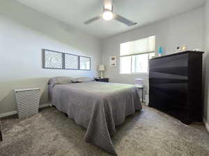 Bedroom featuring carpet floors, baseboards, visible vents, and ceiling fan