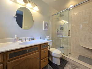 Full bathroom with vanity, a stall shower, and toilet