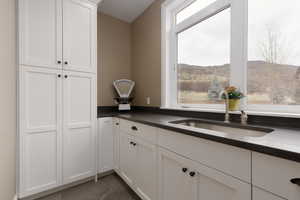 Kitchen with a mountain view, sink, and white cabinets