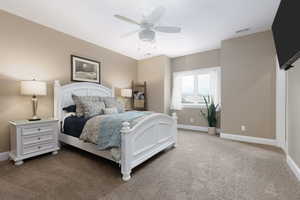 Carpeted bedroom featuring ceiling fan