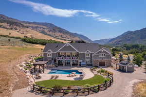 Rear view of property with a yard, a shed, a fenced in pool, a mountain view, and a patio area