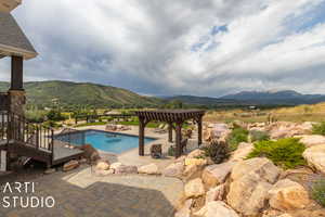 View of swimming pool featuring a mountain view, a pergola, and a patio area