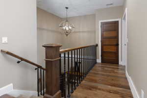 Stairway featuring a chandelier and hardwood / wood-style floors