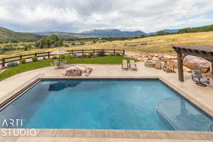 View of swimming pool with a patio, a mountain view, and a pergola