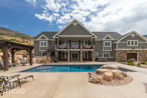 View of swimming pool with a hot tub, a patio, a mountain view, and a pergola