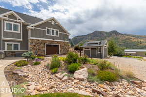 View of front of property with an outbuilding, a garage, and a mountain view