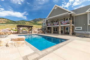 View of pool with a mountain view, a pergola, a hot tub, and a patio