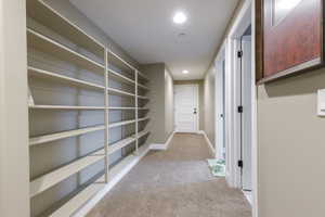 Hall featuring light colored carpet