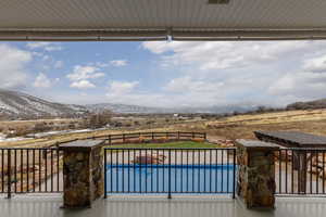 Deck with a fenced in pool and a mountain view