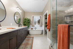 Full bathroom featuring vanity, tile patterned flooring, independent shower and bath, and toilet