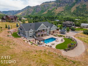 Back of house featuring a mountain view, a pergola, and a patio area