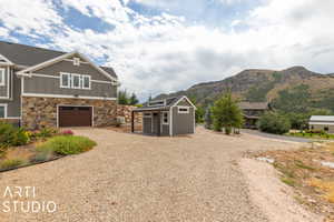 View of side of property with a mountain view and a garage