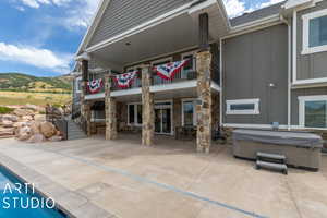 View of patio featuring a mountain view and a hot tub