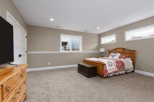 Bedroom featuring light carpet