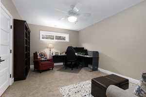 Office space with light colored carpet and ceiling fan