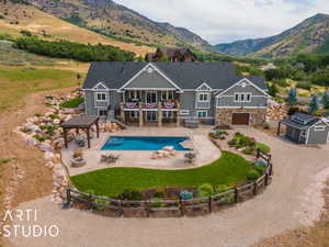 Rear view of property featuring a fenced in pool, a lawn, a patio, a storage unit, and a mountain view