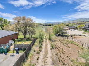 View of yard with a mountain view, fence, and a rural view
