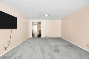 Interior space with carpet flooring, baseboards, and visible vents