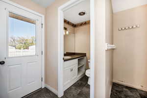 Bathroom with vanity, toilet, marble finish floor, baseboards, and visible vents