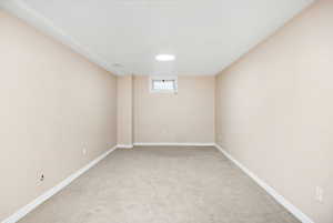 Below grade area with baseboards and light colored carpet